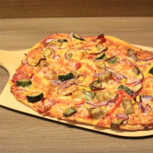 Flammkuchen und Pizzaschieber mit frischer Pizza