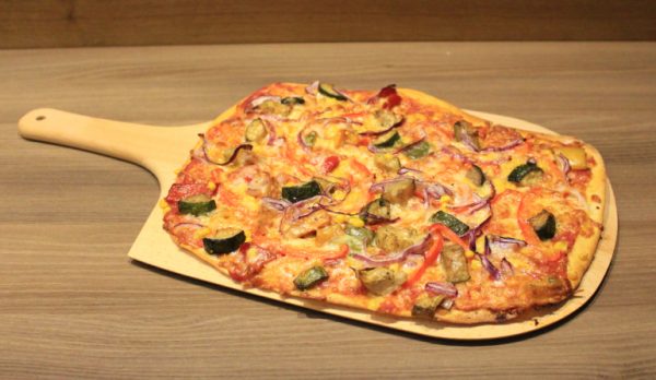 Flammkuchen und Pizzaschieber mit frischer Pizza